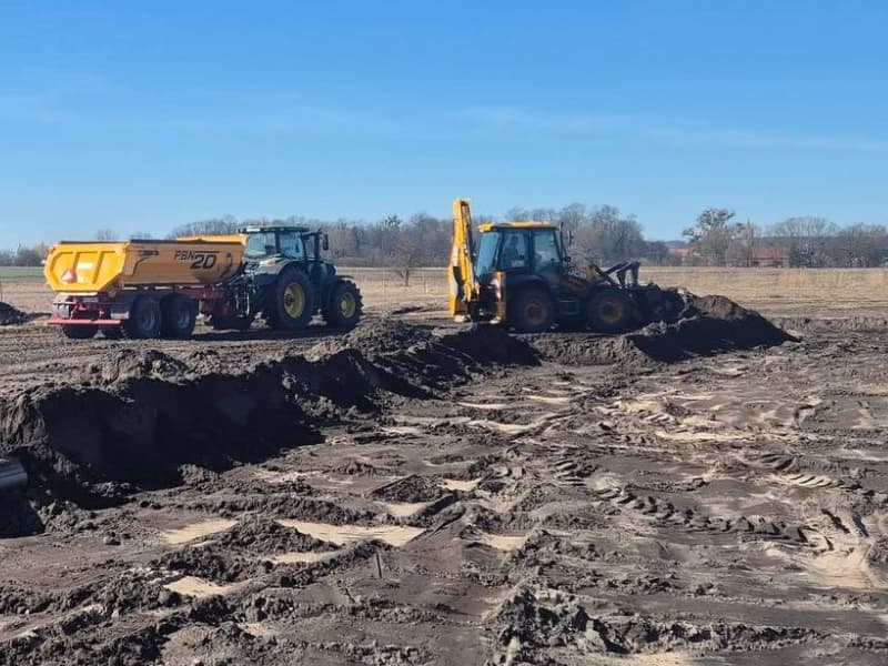 Ciągnik z przyczepą budowlaną i koparko-ładowarka JCB